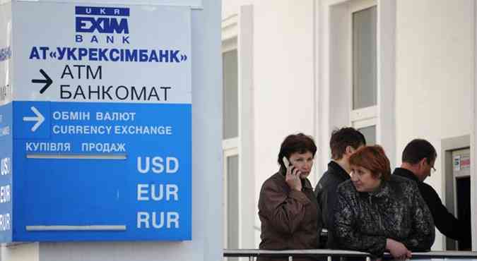 Pessoas aguardam em banco ucraniano. A mudana da moeda hryvnia para o rublo j est valendo(foto: VIKTOR DRACHEV/AFP)