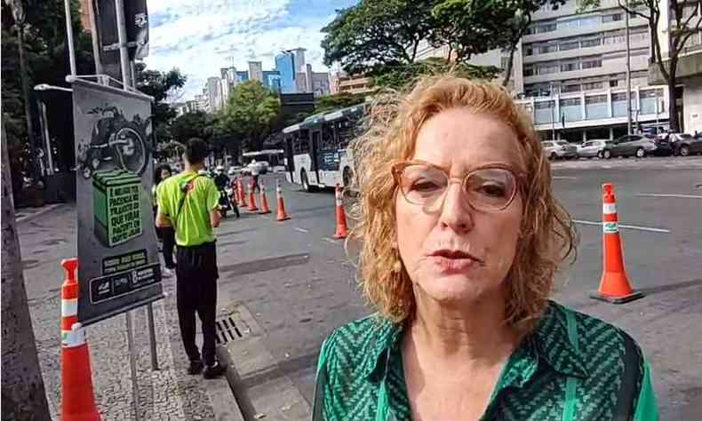 mulher de cabelo ruivo, camisa verde e de culos