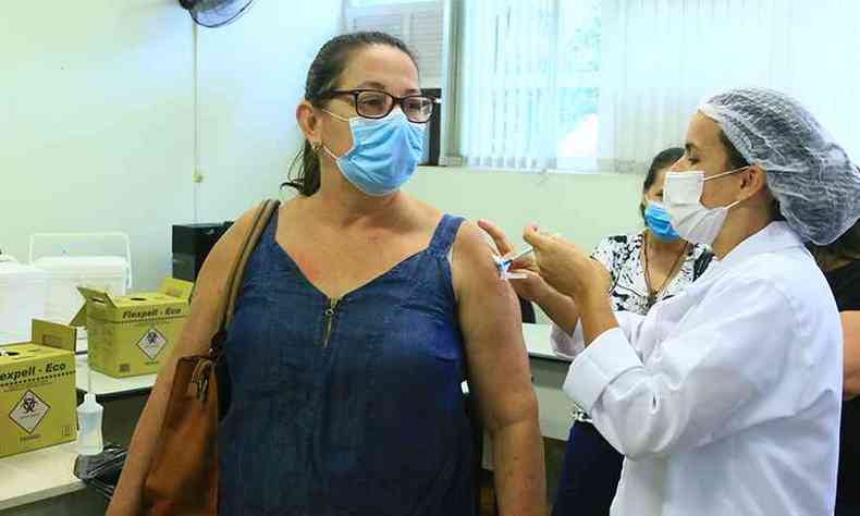 Professora da rede municipal de ensino de Timteo feliz por receber a primeira dose da vacina contra a COVID-19(foto: Prefeitura de Ipatinga/Divulgao)