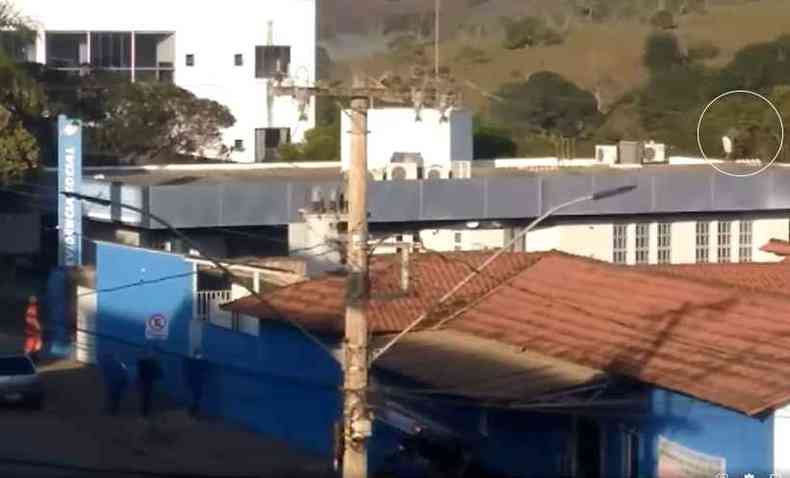 Bombeiros na porta do prdio do INSS tentando resgatar o rapaz no telhado (crculo), ameaando se jogar(foto: Reproduo vdeo Geilton Fernandes / Divulgao)