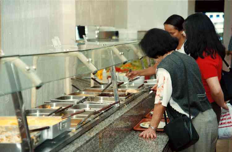 pessoas servem comida em restaurante sellf service 