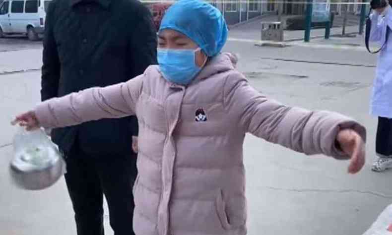 Garotinha chora e abre os braos em um abrao simblico na me, que  enfermeira(foto: Reproduo/New China TV))