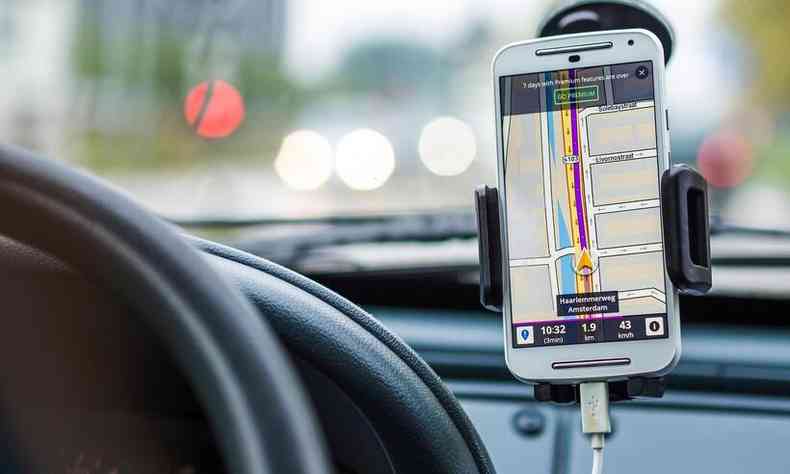 Celular, emsuporte de telefone para carros, prximo ao volante com um mapa e uma rota na tela