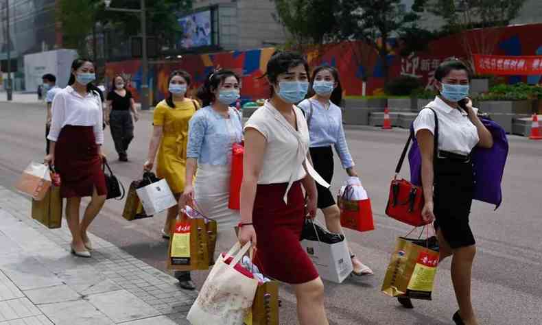 Mulheres chinesas de mscaras na rua 