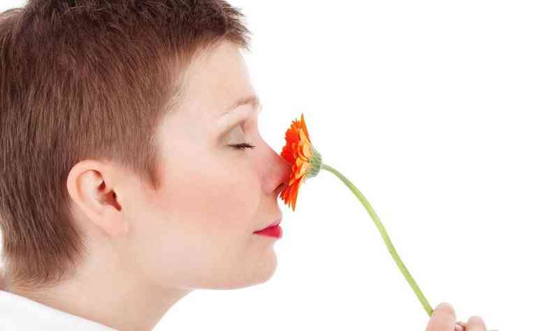 Mulher cheirando uma flor