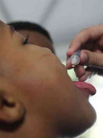Criana tomando  vacina oral poliomielite (VOP)