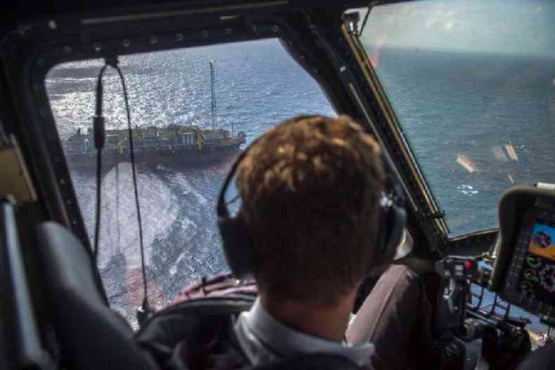 Piloto de helicptero observa plataforma de explorao no mar