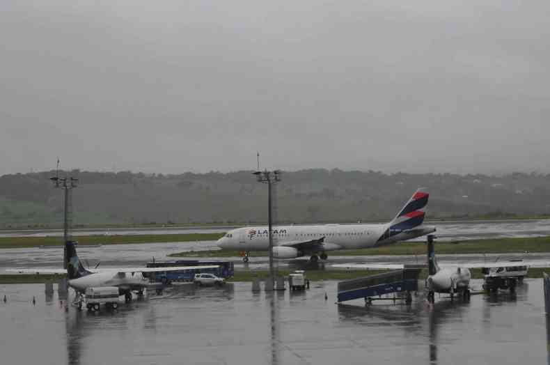 Vista em plano geral de avies parado na pista do Aeroporto Internacional de Belo Horizonte. Pista molhada em decorrncia de chuvas. 