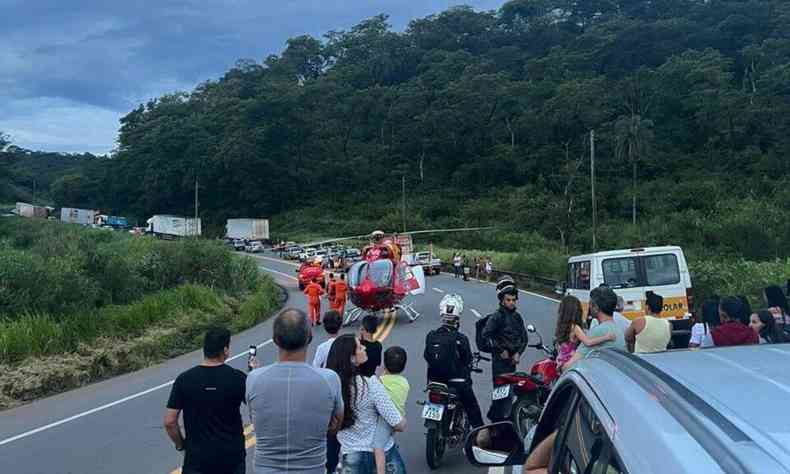 Helicptero na pista da rodovia; h congestionamento de carros e caminhes no local