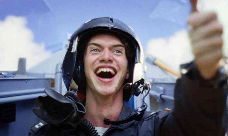 Cena da srie: jovem sorri; ele usa capacete de piloto e est dentro de um avio