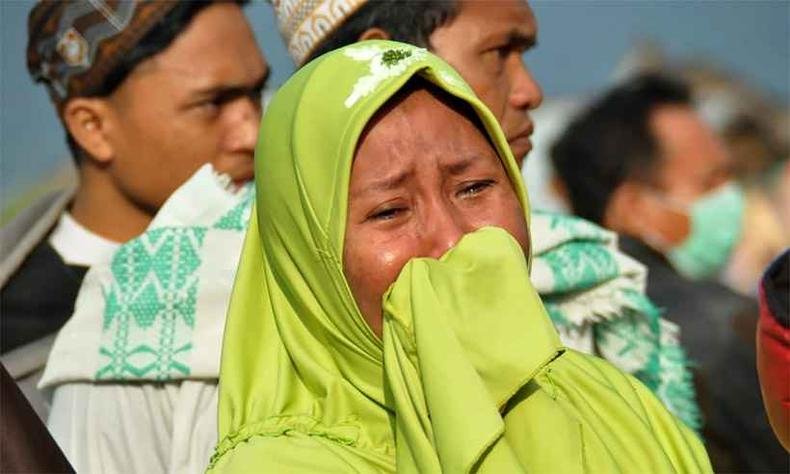 Mulher chora ao ver os danos e mortes causados pelo desastre na Indon�sia(foto: MUHAMMAD RIFKI / AFP)