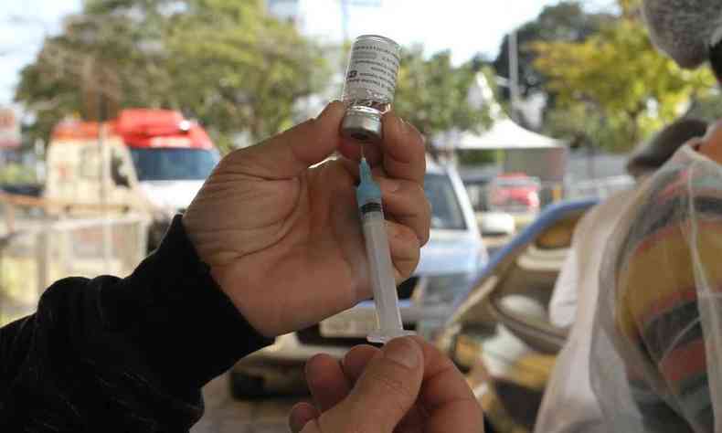 Posto drive-thru na UFMG. Seringa e frasco com vacina