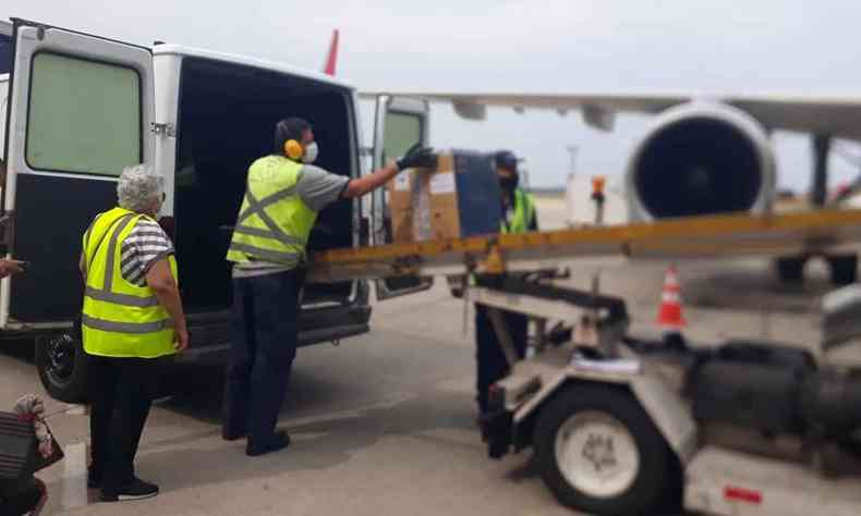 Equipe do aeroporto de Confins transporta caixas da vacina da Pfizer