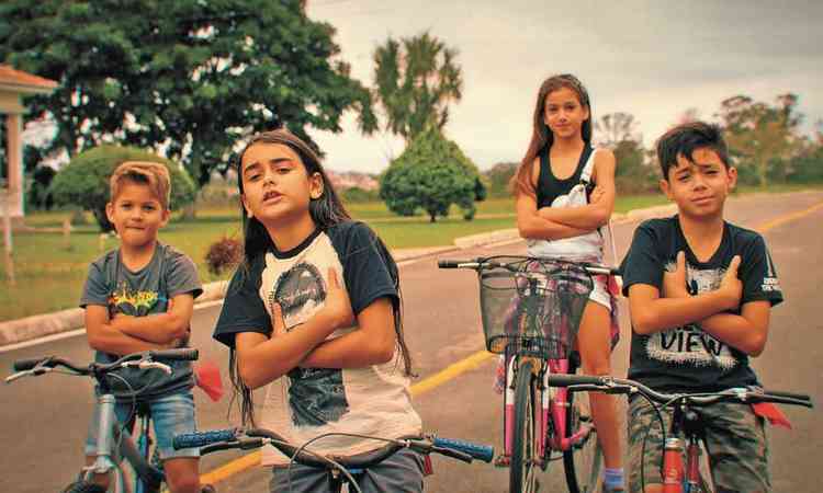 Quatro crianas de braos cruzados e olhar de desafio, montadas em bicicletas, no filme Sobre amizades e bicicletas