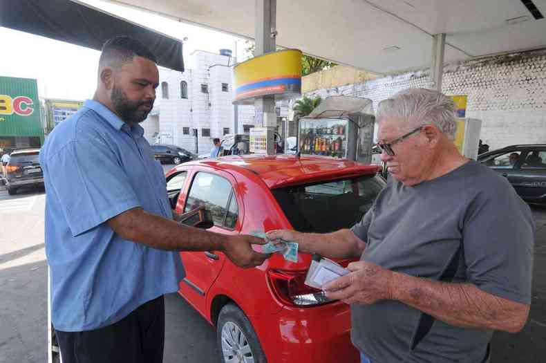 Cliente dando dinheiro do pagamento ao frentista