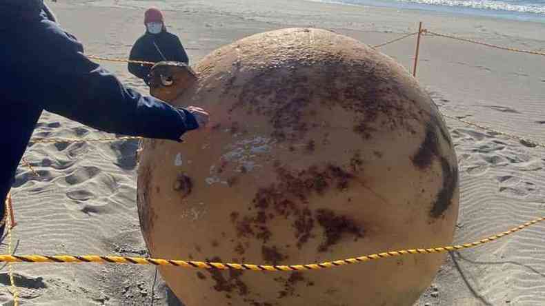 Esfera metlica na areia da praia