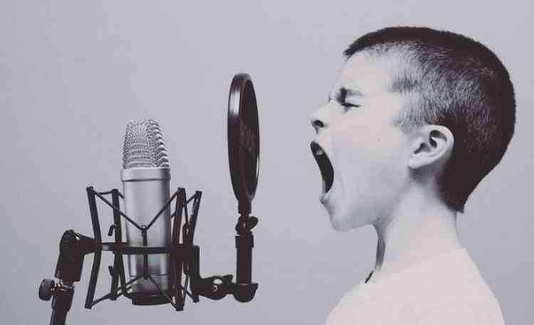 Menino cantando em frente ao microfone