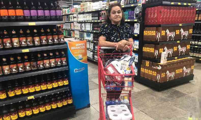 Mulher com carrinho de compras em supermercado