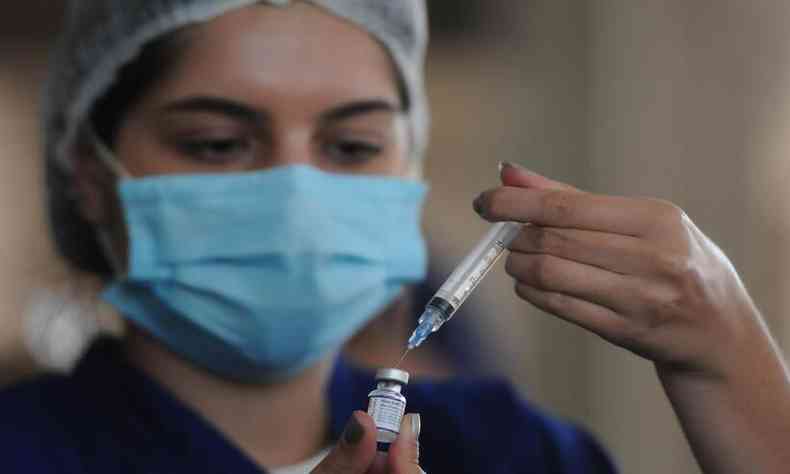 Profissional de saúde prepara a seringa para aplicação da vacina contra a COVID