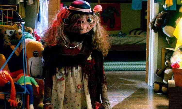 Personagem ET vestido de mulher, com chapu e bolsa, em cena do filme ET - O extraterreste