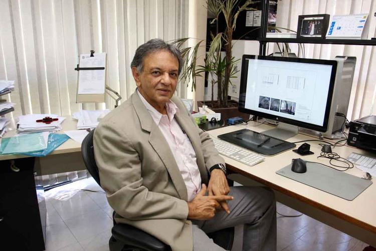 Joel Campolina est sentado em frente ao computador e olha para a cmera