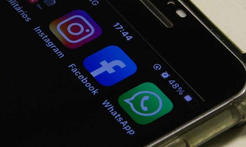 Parte superior direita de um smartphone na qual aparece na tela os aplicativos Instagram, Facebook e WhatsApp. 