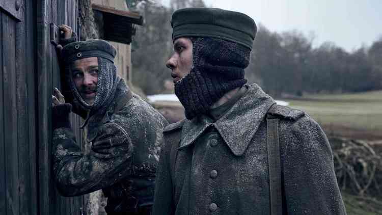 Dois soldados na neve, um com o ouvido na porta de uma casa de mandeira e o outro olhando para ele