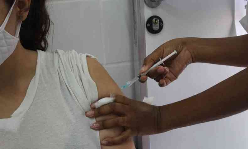 mulher recebe vacina contra COVID-19
