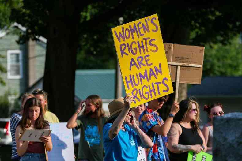 Manifestando segurando cartaz em que se l: 'Direitos das Mulheres so direitos humanos' durante marcha pelos direitos das mulheres nos EUA