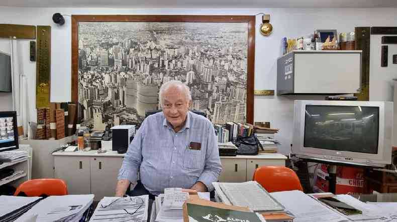 Homem sentado com foto do centro de So Paulo ao fundo