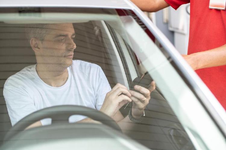 Homem pagando por combustvel em posto de gasolina
