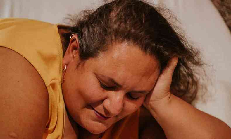 foto mostra a colunista Jssica Balbino deitada sobre uma cama, apoiando a cabea com o brao esquerdo