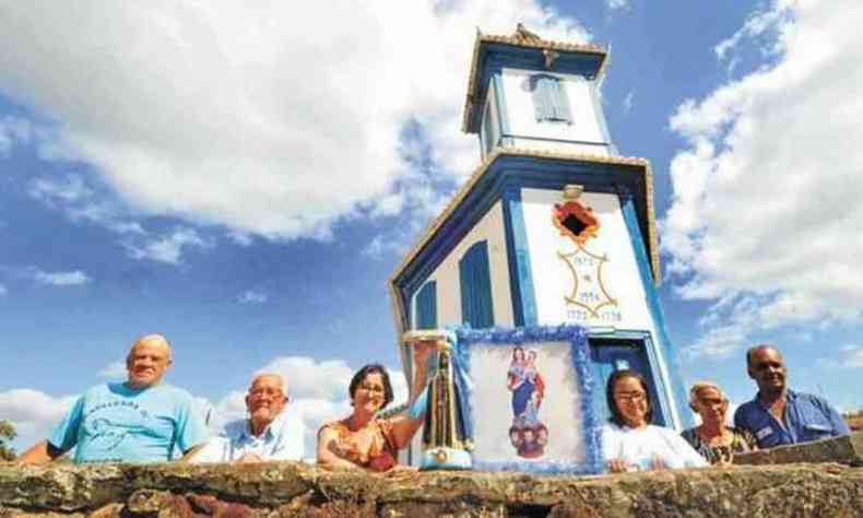 Devotos mostram a imagem de Nossa Senhora Aparecida ao lado da bandeira da padroeira do distrito em Minas Gerais (foto: Jair Amaral EM DA Press)