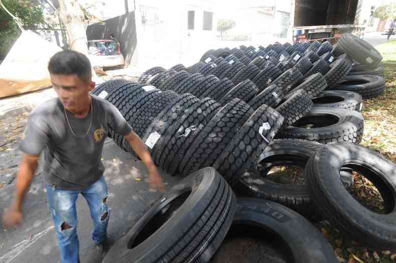 Homem ajuda a recolher os pneus
