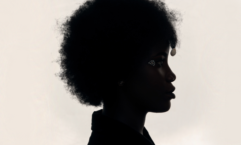 Mulher negra com black power de perfil em um fundo branco