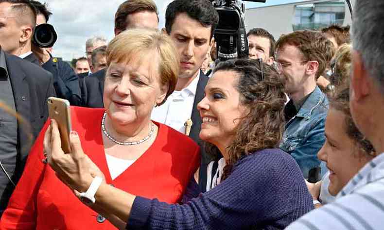 A chanceler Angela Merkel tira selfie com eleitora, mas perdeu popularidade(foto: Tobias Schwarz/AFP)
