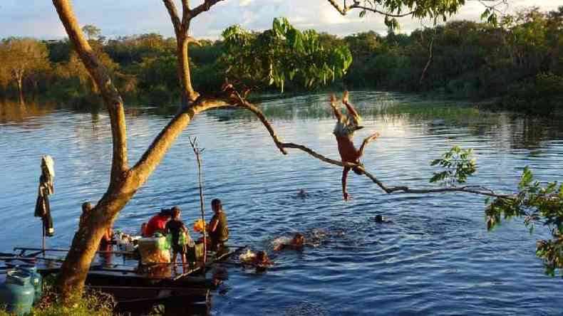 Crianas ribeirinhas brincam no rio enquanto mulheres lavam roupa, em Juta (AM)