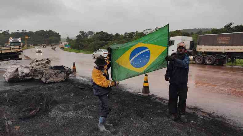 Mesmo depois do fim das manifestaes a BR-040 em Congonhas registrou trfego lento caminhes parados na estrada por manifestao de caminhoneiros Dois manifestantes ainda sujos de minrio e da foligem dos pneus que queimaram abrem bandeira do Brasil na BR-040