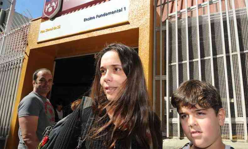 Raquel Lima e o filho  porta de escola que manteve aulas. 'Acho que vamos comear a vir a p', diz a me da criana (foto: Leandro Couri/EM/DA Press)