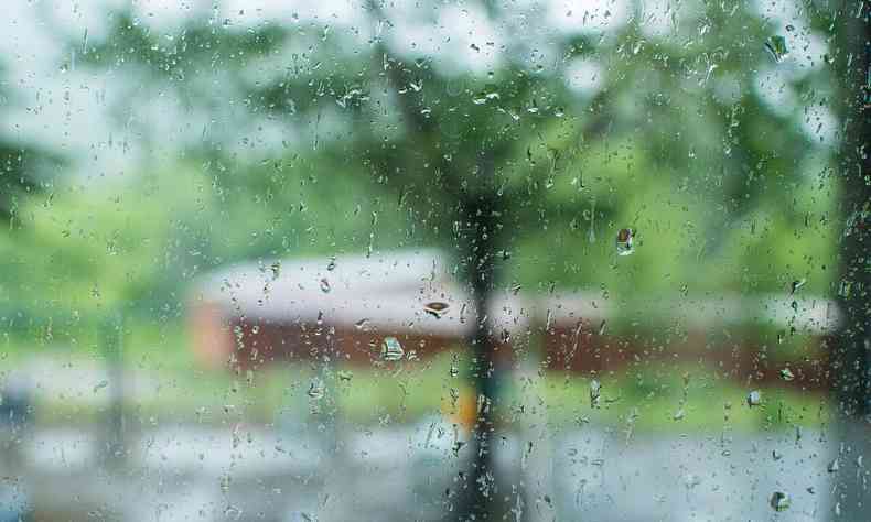 Gotas de chuva em janela, com fundo desfocado de construo em praa