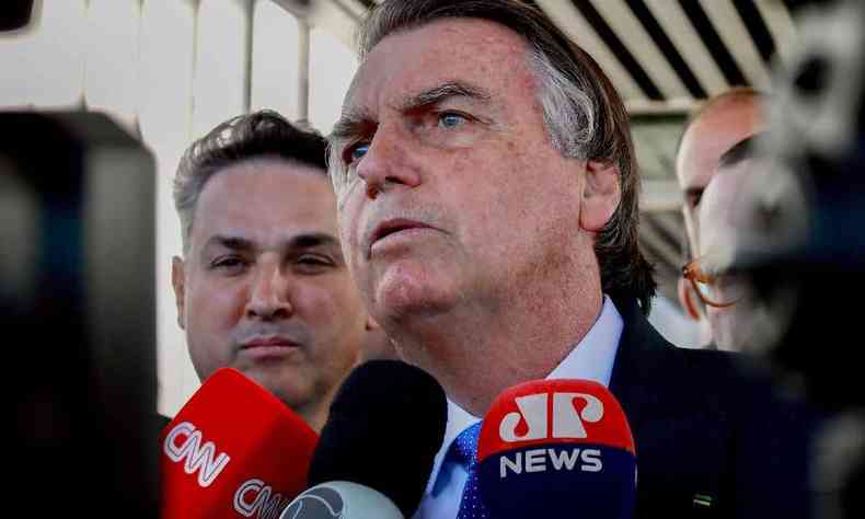 Jair Bolsoanro cercado por microfones em coletiva de imprensa