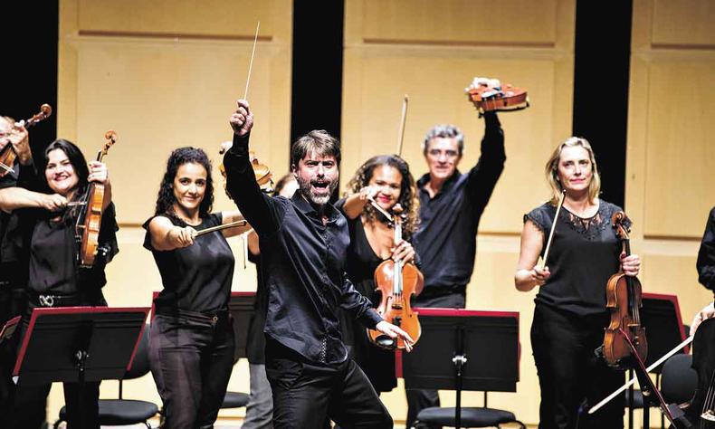 Maestro Felipe Magalhes e a Orquestra Sesiminas, de braos levantados, brincam alegremente com o pblico