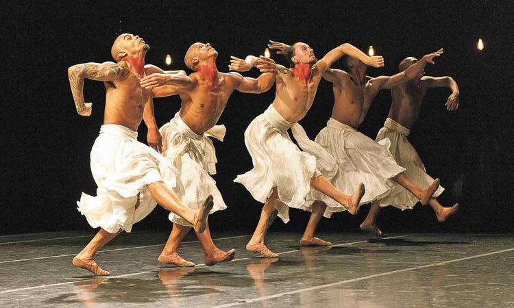 Bailarinos do Grupo Corpo olham para cima enquanto danam, durante a coreografia Gira