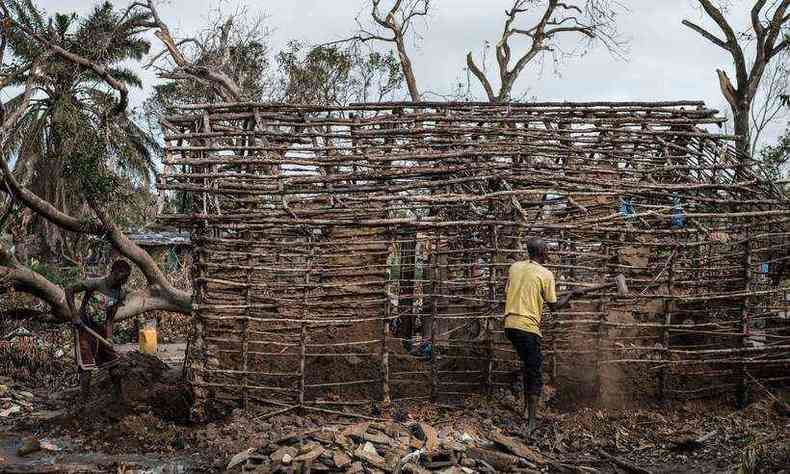 Em Beira, homens removem o bambu restante na tentativa de consertar suas casas, destrudas aps a passagem do ciclone Idai(foto: Yasuyoshi Chiba/AFP)