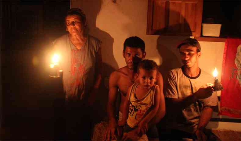 A famlia de Maria de Oliveira resiste  luz de lamparinas em uma das poucas casas que restaram na comunidade semiabandonada: 'Daqui, s saio morta'(foto: Sidney Lopes/EM/D.A Press)