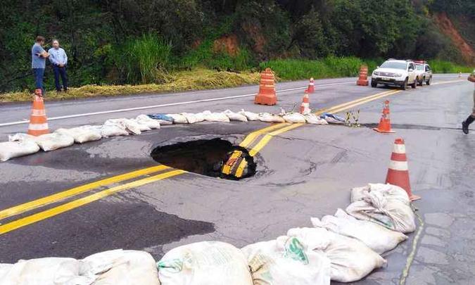 Apesar de a área ter sido isolada com sacas e cones, o entorno do buraco apresenta rachaduras e risco de cedimento (foto: Polícia Militar Rodoviária/ Divulgação ) Apesar de a área ter sido isolada com sacas e cones, o entorno do buraco apresenta rachaduras e risco de cedimento (foto: Polícia Militar Rodoviária/ Divulgação )
