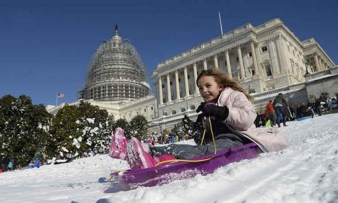 Após nevasca, americana desliza no gramado ocidental do Capitólio dos EUA, em Washington(foto: AFP/Olivier Douliery ) Após nevasca, americana desliza no gramado ocidental do Capitólio dos EUA, em Washington(foto: AFP/Olivier Douliery )