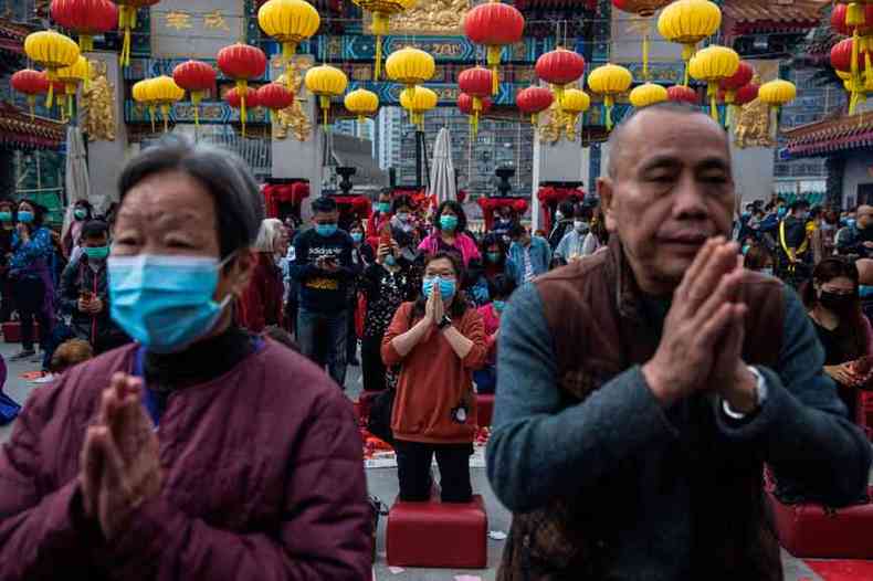 Com muitas celerabraes de ano novo suspensas, o que valeu em Hong Kong foi a prece de pessoas que usavam mscaras como preveno (foto: Dale de La Rey/AFP )