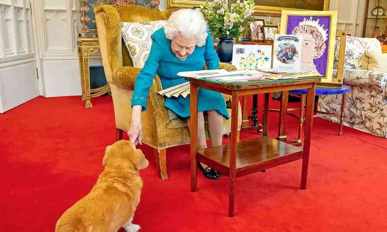 Rainha Elizabeth II acariciando um cachorro