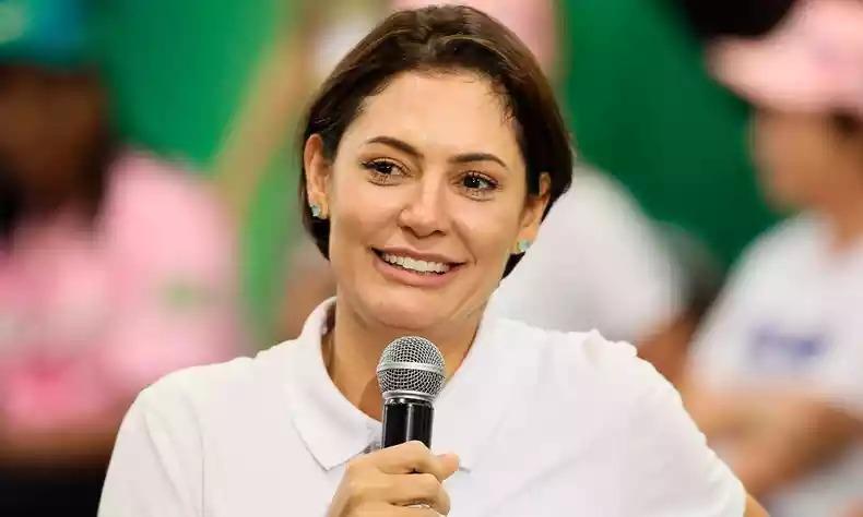 Michelle Bolsonaro sorri com microfone na mo